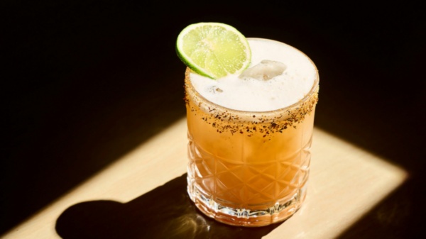 Drinkkikoulussa valmistettu oranssinvivahteinen cointreau sour, jossa lisäksi pippuririmmi lasin reunassa